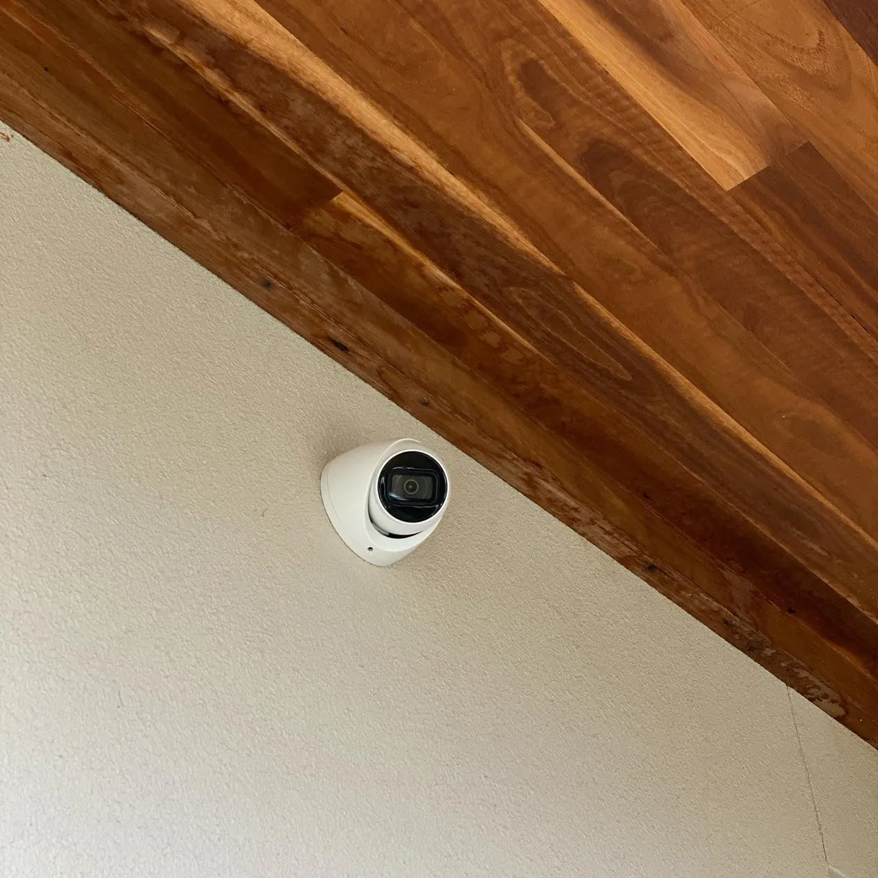 Dome security camera installed neatly under an eave