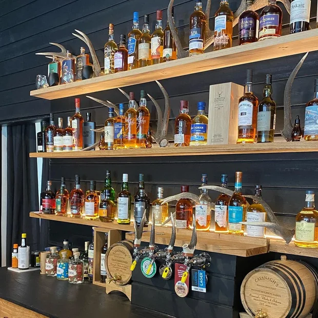 Lit bar shelving stocked with bottles