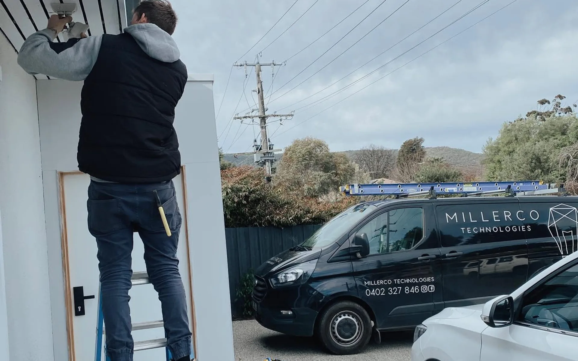 MillerCo electrician working at a house beside the work van