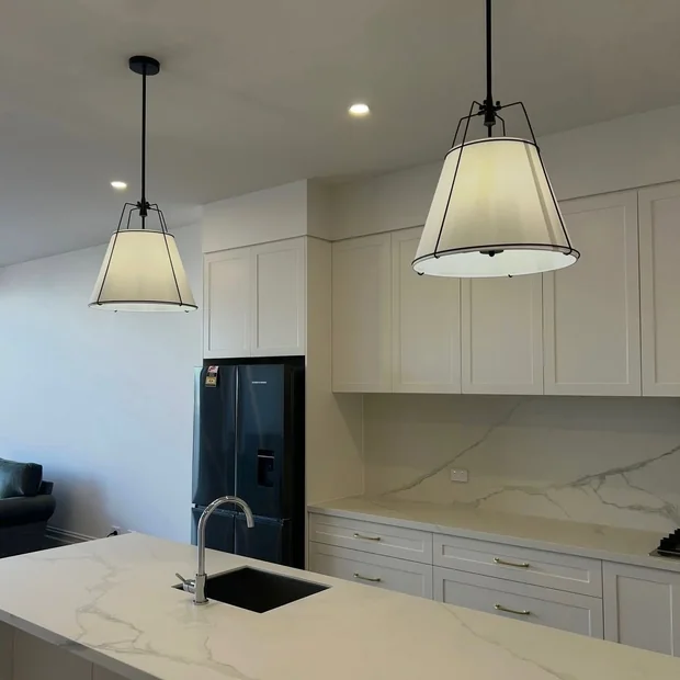 Two pendant lights hanging over a kitchen bench