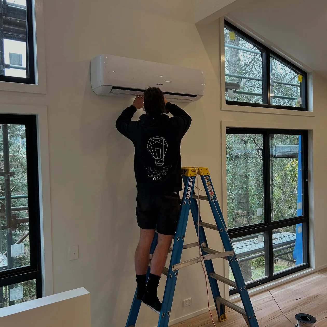 MillerCo electrician installing a wall-mounted split system head unit