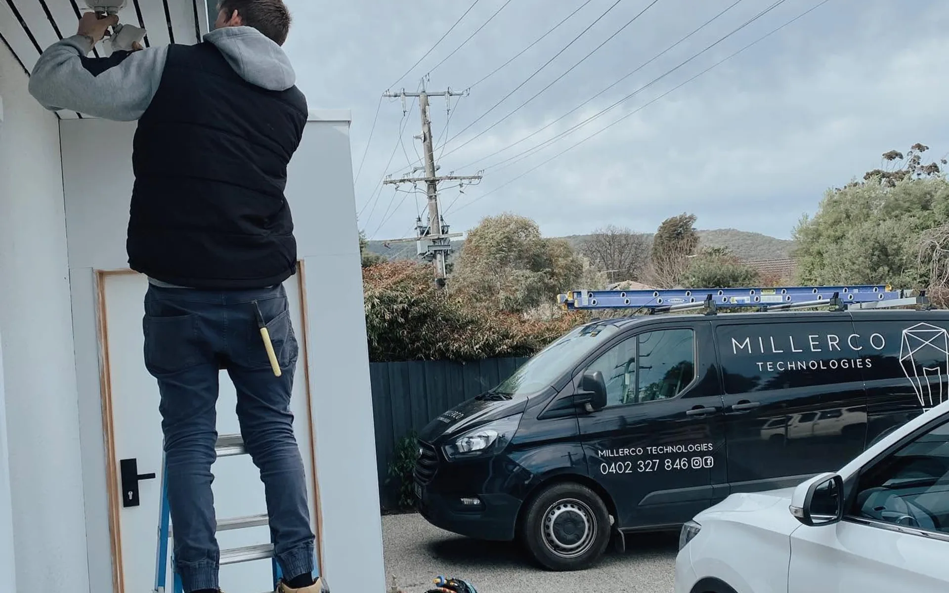 MillerCo electrician working on site beside the work van